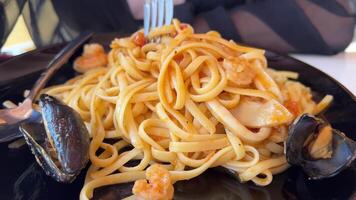 heerlijk Italiaans zeevruchten pasta met mosselen en garnalen. chef sprenkeling schotel met kruiden en microgroenten. langzaam beweging. chef hand- zet kruiden Aan top van pasta schotel afgewerkt voordat portie. vol hd video