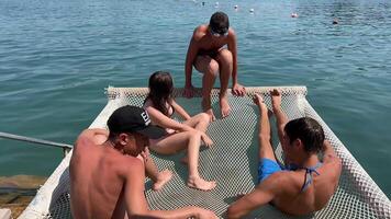 Teenager Ferien auf das ionisch Meer Albanien Jugend freunde Lüge auf ein Hängematte Über das Fluss Meer springen in das Wasser stürzen Kommunikation einer Mädchen und vier Jungs Albanien ksamil video