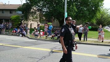 policía procesión durante gera desfile hombres en Gafas de sol y policía uniformes caminar abajo el calle ondulación actuación y celebracion ley y orden libertad de elección reloj el calle trébol video