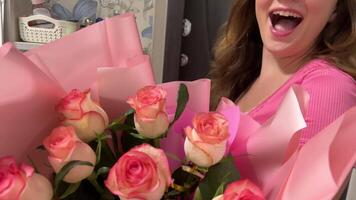 international congratulations agency flower delivery young girl opens the door meets the messenger with a bouquet birthday joy happiness roses pink home furnishings video