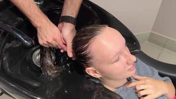 hår tvättning närbild. tvättning av schampo från blond lång hår. hår färg. på hår salong eller frisör. video
