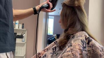 uma homem cabeleireiro lavagens mulher cabelo depois de tingimento dela cabelo. fechar-se video