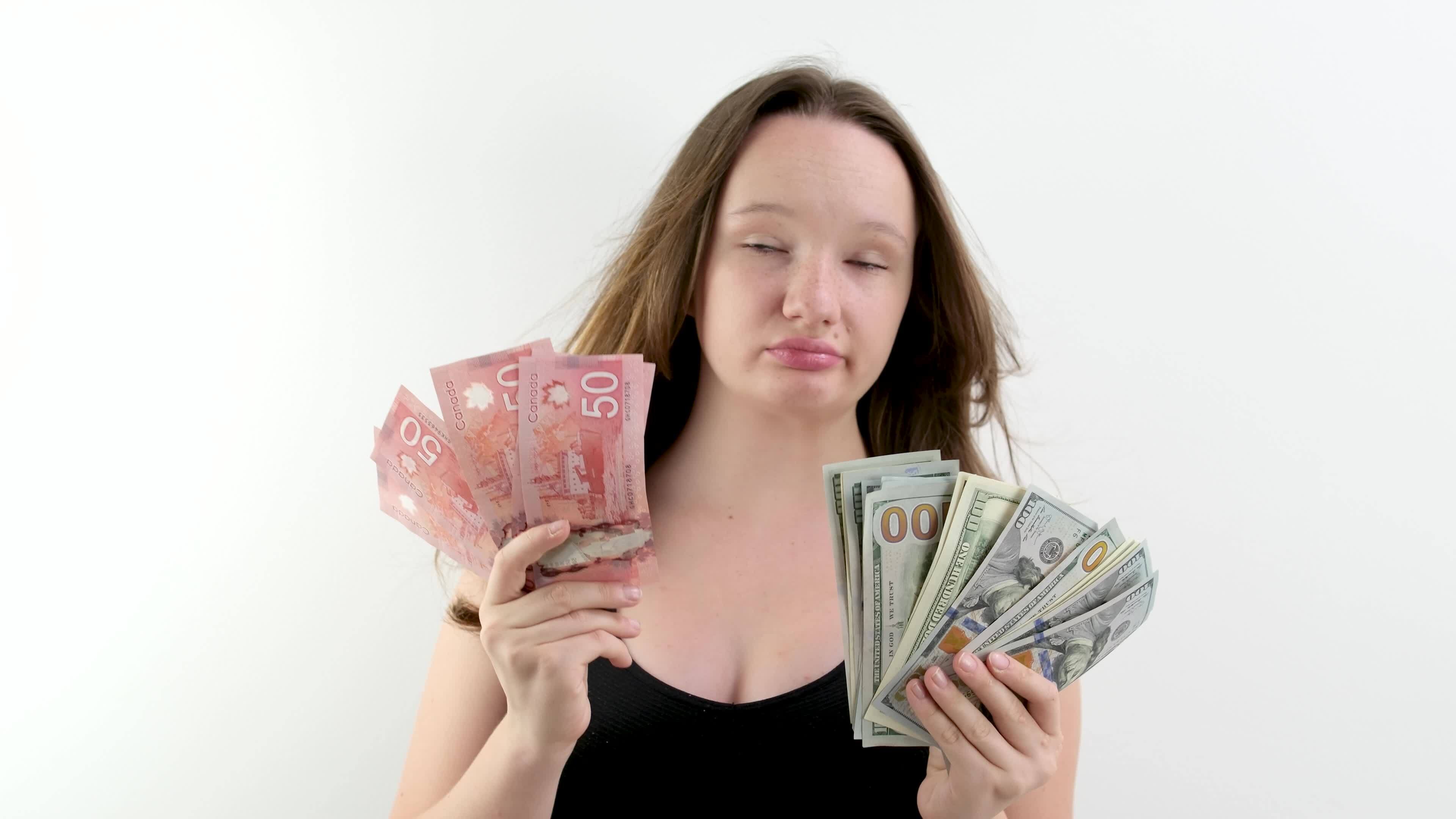 Choice Between Canadian Dollars And US Dollars Girl Weighs In Her Hands choice-between-canadian-dollars-and-us-dollars-girl-weighs-in-her-hands