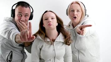 man and two women teenage girl doing negative Swing with index finger No don't do it look into the frame extending hand with finger forward headphones tracksuits white background video