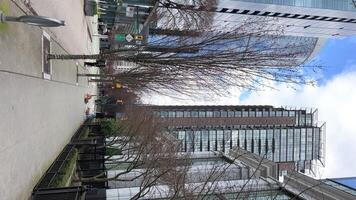 real vida en el grande ciudad rascacielos claro cielo con nubes primavera desnudo arboles sin hojas Vancouver Canadá video
