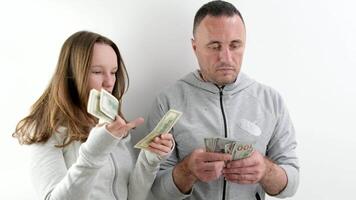 father teaches daughter business to count money old 100-dollar bills and new banknotes stand family stands near the wall consider talking communicate video