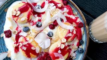 oben Aussicht von Pfannkuchen mit Erdnuss Butter Verbreitung entlang mit Früchte eine solche wie Banane, Blaubeeren und Himbeeren bedeckt mit Kokosnuss Flocken, gesund Frühstück Konzept video