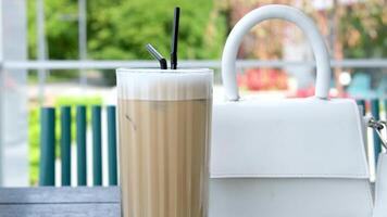 latte macchiato in mooi kop Aan een geïsoleerd wit achtergrond met natuurlijk schaduw. cappuccino schuimend koffie en melk drinken in een transparant glas beker. chai latte gieten schot. chai latte drankje. video