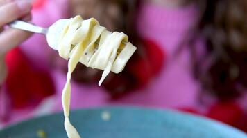 inkompetent flicka wraps spaghetti på en gaffel piatto di deliziosi spaghetti alla carbonara, una tipica ricetta di pasta condita lura una salsa en bas di uova, pecorino e guanciale, cibo italiano video