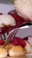 cocido dulce vienés gofres gofres con crema y frambuesas pequeño tarta con fresas y crema en blanco plato en cafetería, macro Disparo video