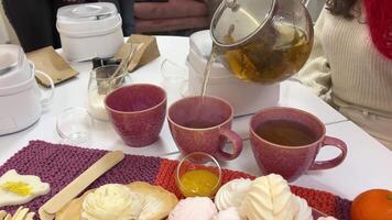 haciendo té en vaso taza con té colador en blanco cocina mesa. video