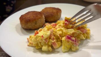 twee vlees schnitzels salade van krab stokken. gekleed met mayonaise. groente, rijst en maïs. imitatie vlees.russisch keuken, huisgemaakt eten.op een wit bord roteert. stevig, smakelijk en voedzaam voedsel. video