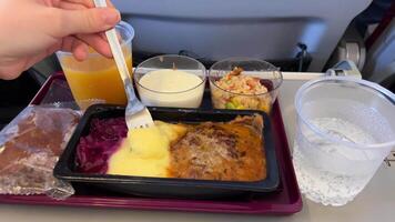comidas son servido en tablero el economía clase aeronave en un mesa. video