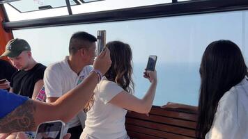 Phu Quoc, Vietnam 02.25.2024 People film on mobile phones from the window of the cable car cabin, people of different nationalities travel on an excursion Phu Quoc island Vietnam video