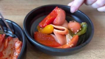 uma jovem menina come Kimchi dentro uma restaurante. Kimchi repolho dentro coreano restaurante, famoso fermentado Comida a partir de Coréia video