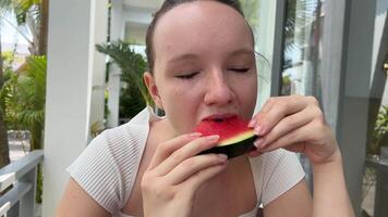 jung Mädchen im Brille isst ein Wassermelone im das Garten Mädchen glücklich mit Wassermelone lächelnd video