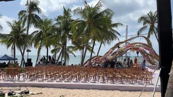 vietnam phu quoc ö 2024-03-28 bröllop dekor strand uppsättning upp havet blommig bäst bröllop Västra detaljer trä stolar guld begrepp. miljö skede festlig äktenskap mönster tropisk ö solnedgång. video