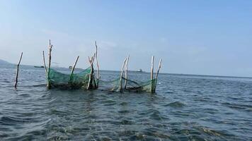 visnetten Bij de strand visvangst netten in de Indisch oceaan in Vietnam phu quoc eiland voorbijgaan door golven vissers arm leven overleving vis landbouw video