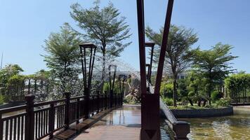 Vietnam Phu Quoc Island Grand World 03.18.2024 Wooden bridge with a fountain to get wet A head with a stream of water flowing out like a hair sculpture Vietnam Grand World Phu Quoc. Sculptures video