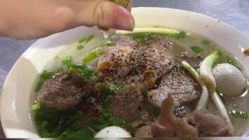 Pho Bo, a Vietnamese soup consisting of broth, rice noodles, herbs, and beef. Popular street food in Vietnam. Popularized throughout the world by refugees after the Vietnam War. Variable sauce added. video