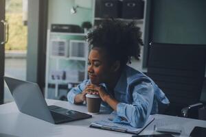 Sad tired young asian lady thinking, sleep at laptop, suffering from overwork, stress in room interior. Deadline, problems in study, work, business, freelance at home new normal with tech photo