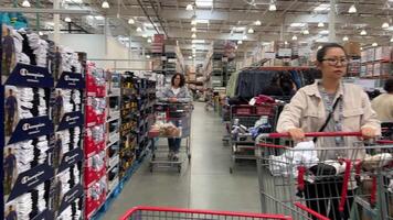 Costco Wholesale Shopping cart buy clothes in a supermarket real people in the city of Vancouver go shopping with big carts and face a lot of people choose look at the price tags video