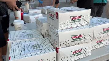 krespy Kreme fondsenwerving Vancouver Canada 2023 jong Aziatisch mensen verkopen donuts in wit dozen punt naar punt de menigte komt in maskers en zonder maskers Kiezen naar schenken video
