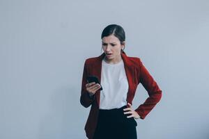 Upset young asian woman holding smartphone standing on isolated white background. She was very stressed and depressed. photo