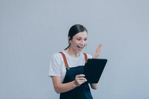 Cheerful beautiful Asian woman wearing jeans overalls with excited doing winner gesture with arms raised isolated on white background. photo