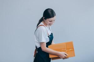 Smiling Asian woman in casual clothes holding a cardboard box mockup while standing against an isolated white background. shipping business concept photo