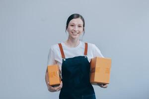 Smiling Asian woman in casual clothes holding a cardboard box mockup while standing against an isolated white background. shipping business concept photo