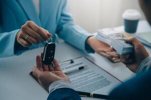 Insurance officers hand over the car keys after the tenant. have signed an auto insurance document or a lease or agreement document Buying or selling a new or used car with a car photo