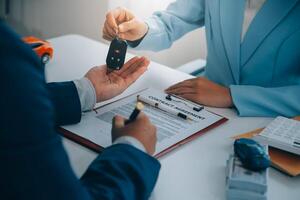 Insurance officers hand over the car keys after the tenant. have signed an auto insurance document or a lease or agreement document Buying or selling a new or used car with a car photo