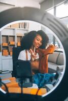 Fashion blogger concept, Young Asian women selling clothes on streaming.Startup small business SME, using smartphone or tablet taking receive and checking in office photo