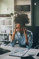 business woman sitting at work stressed , out working hard Feeling stressed out and dizzy from your job photo