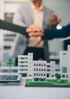 Two business executives, elegantly attired in suits, join hands in a gesture of unity, solidarity, and shared commitment towards a common goal or venture. photo