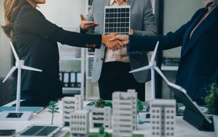Two business executives, elegantly attired in suits, join hands in a gesture of unity, solidarity, and shared commitment towards a common goal or venture. photo