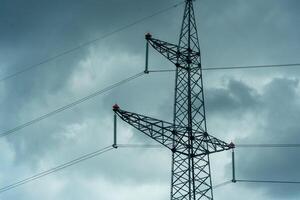 High voltage towers with sky background. Power line support with wires for electricity transmission. High voltage grid tower with wire cable at distribution station. Energy industry, energy saving photo