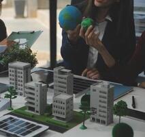 Business people having consultation about wind energy at company office. Business team discussing about windmill and alternative green energy. Executive meeting at modern office photo
