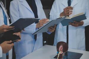 médico, reunión y ordenador portátil para equipo en oficina en discusión, lluvia de ideas y planificación. doctor, enfermero y computadora en escritorio, trabajo en equipo o taller para modelo interno Organo. foto