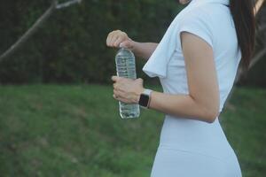 joven mujer Bebiendo proteína sacudir al aire libre foto