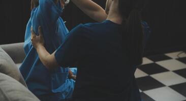 Old woman training with physiotherapist using dumbbells at home. Therapist assisting senior woman with exercises in nursing home. Elderly patient using dumbbells with outstretched arms. photo