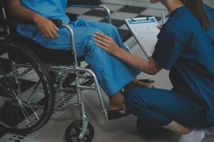 Young physiotherapist exercising with elder disabled person photo