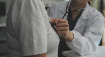 Doctor using sphygmomanometer with stethoscope checking blood pressure to a patient in the hospital. photo