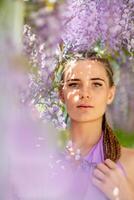 Woman wisteria lilac dress. Thoughtful happy mature woman in purple dress surrounded by chinese wisteria photo