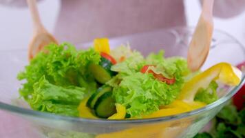 evenwichtig eetpatroon, gezond voedsel concept Aan houten bord. visie van bovenstaand groente salade van een glas bord met een houten spatel roeren groenten video