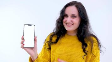 sorridente chocado feliz ganhar lindo jovem mulher 20s anos velho dentro amarelo suéter posando isolado em branco fundo dentro estúdio. pessoas estilo de vida conceito. Veja surpreso Uau aguarde usando Móvel célula telefone video