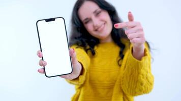 point finger at phone thumb up phone with white screen Beautiful woman holding smartphone mockup of blank screen and shows ok sign on grey background video