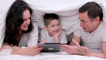 familjer med barn i säng under en filt video