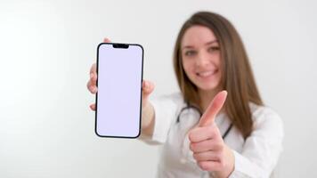 jong vrouw in wit jeans houdende Aan bankstel toepassingen smartphone met vooraf ingetoetst groen scherm. weinig types van gebaren scrollen omhoog en omlaag, tikken, zoom in en uit. perfect voor scherm compositing video